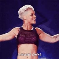a woman in a purple top is dancing on a stage .
