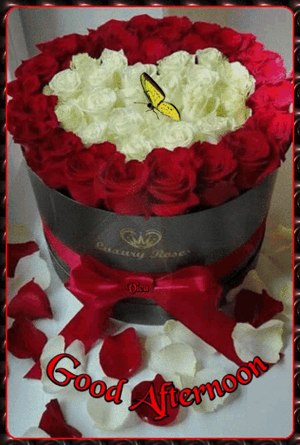 a bouquet of red and white roses in the shape of a heart with a butterfly