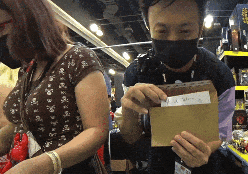 a man wearing a mask is holding an envelope with a note in it that says " i am where "