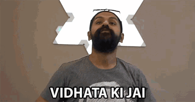 a man with a beard is wearing a t-shirt that says " vidhata ki jai "