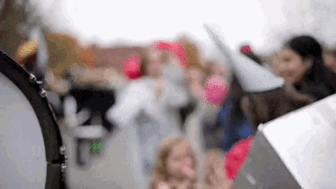 a blurry picture of a crowd of people holding signs and balloons
