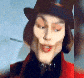 a close up of a person wearing a top hat and making a face