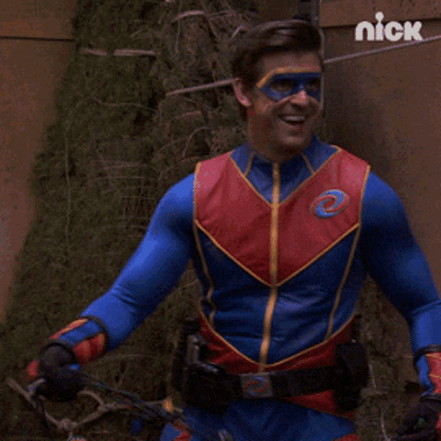 a man in a blue and red superhero costume is smiling in front of a nick logo