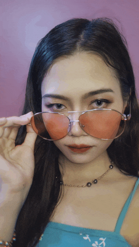 a woman wearing a pair of pink sunglasses