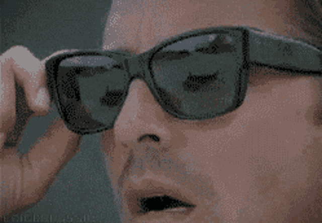 a pixelated image of a man wearing sunglasses with the word ray-ban on the bottom left