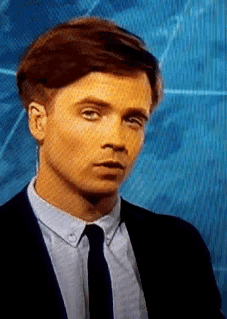 a man in a suit and tie is making a face