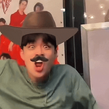 a man wearing a cowboy hat and a fake mustache is making a funny face