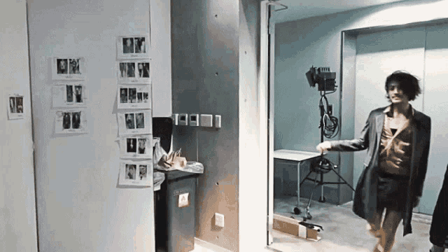 a woman in a suit is walking through a room