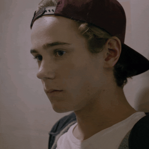 a close up of a young man wearing a hat with the letter a on it