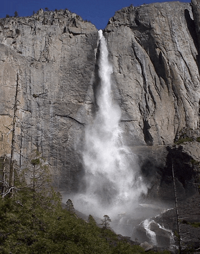 a waterfall is coming down the side of a rocky cliff