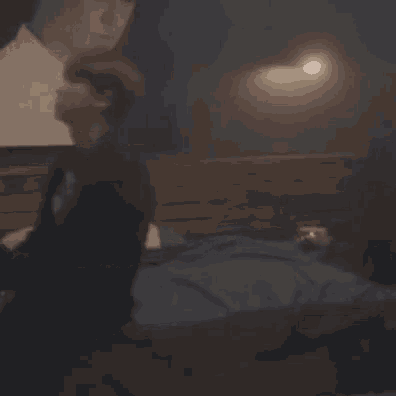 a man is laying on a bed watching a movie on a tv .