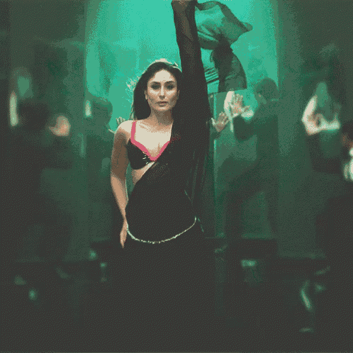 a woman in a black bra and black skirt is dancing