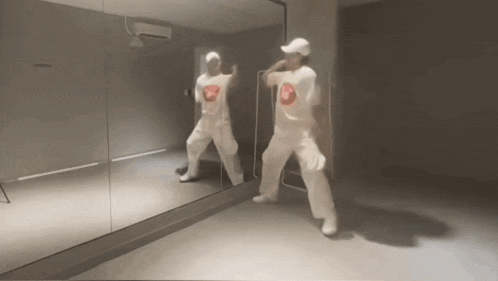 a person dancing in front of a mirror wearing a shirt that says nike