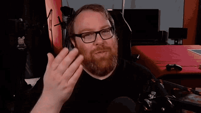 a man with a beard wearing glasses and a black shirt