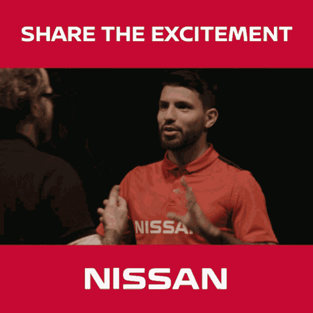 a man in a red nissan shirt talks to another man