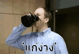 a man is drinking a cup of coffee from a coffee pot .