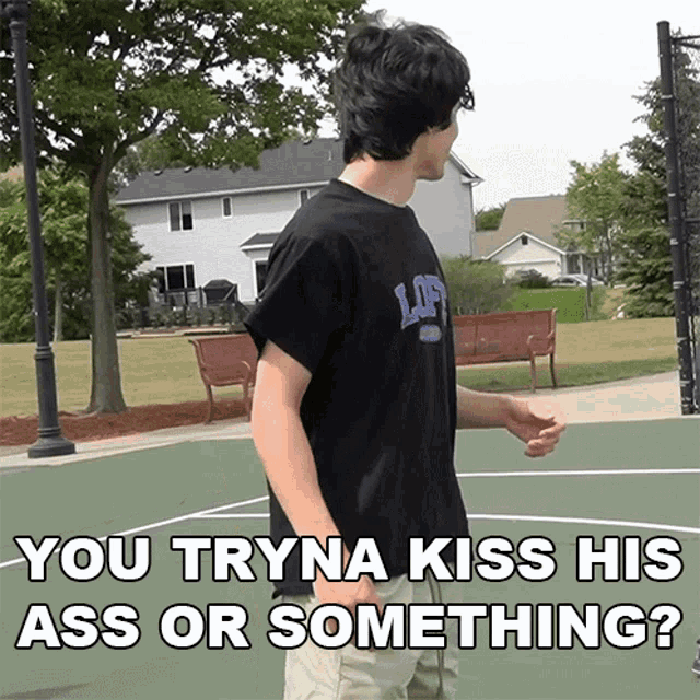 a man wearing a black shirt that says loft stands on a basketball court