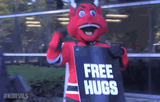 devil mascot holding a sign that says " free hugs "