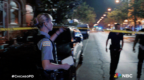 a woman in a chicago police uniform stands on a street