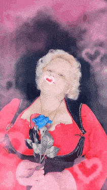 a woman in a red dress holds a blue rose in her hand