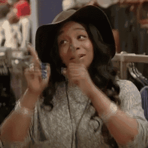 a woman wearing a hat and headphones is making a funny face in a clothing store .