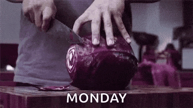 a person is cutting a purple cabbage on a cutting board with a knife .