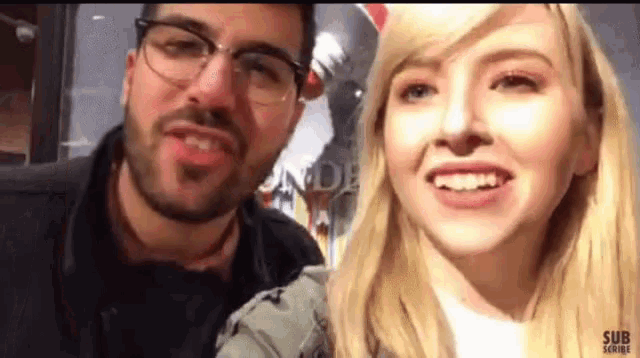 a man and a woman are standing next to each other and the woman is smiling