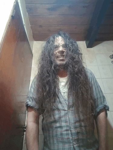 a man with long curly hair wearing glasses