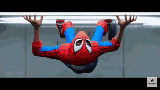 a spider man is hanging upside down from a bar
