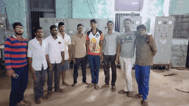 a group of men are posing for a picture and one of them has a fila shirt on