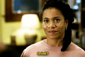 a woman is wearing a pink sweater and smiling while asking if she can drink .