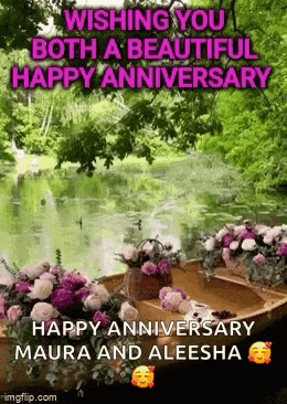 a boat filled with flowers is floating on a lake .