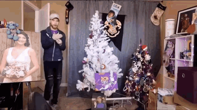 a man stands in front of a white christmas tree with a picture of a bride on it