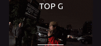 a man stands in a parking lot with the word top g above him