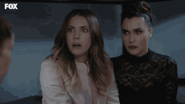 two women are sitting next to each other with the fox logo on the bottom