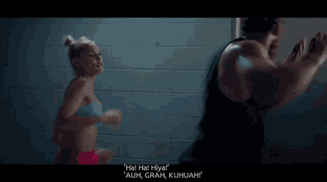 a man and a woman are standing in front of a brick wall and the woman says " ha ha hiva "