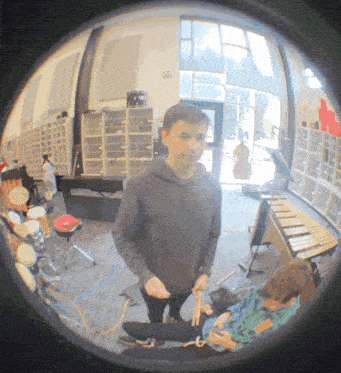 a man stands in a room with drums and a keyboard