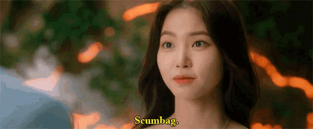 a close up of a woman 's face with the words scumbag on the bottom .