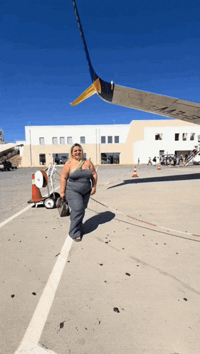 a woman standing in front of an airplane with a wing that says ' united airlines ' on it