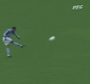 a soccer player kicks a ball in front of an inflatable banner that says coritiba foot