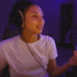 a woman wearing headphones and glasses is sitting in front of a computer screen .