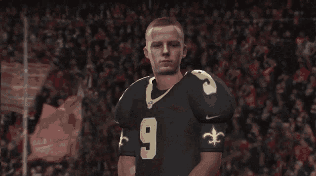 a football player with the number 9 on his jersey stands in front of a crowd