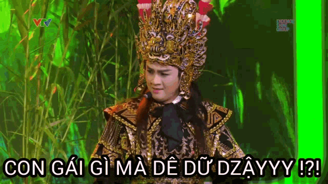 a man in a costume is standing in front of a green screen that says con gai gi ma de du dzayyy