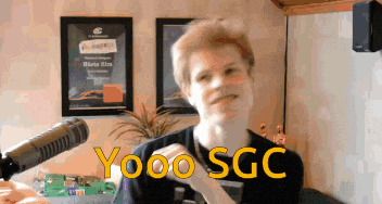 a man stands in front of a microphone with the words yooo sgc written on his face