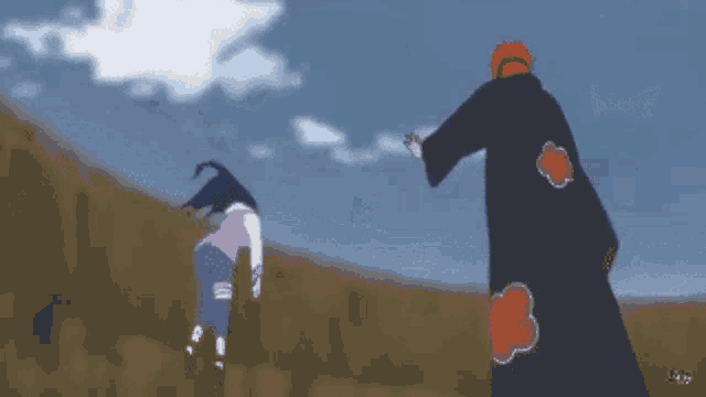 a man in a black robe with red clouds on the back is standing next to a woman in a pink shirt .