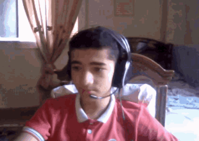 a young man wearing headphones and a red shirt