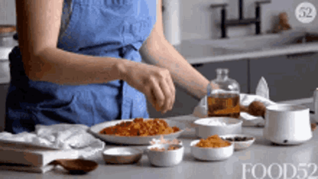 a woman in a blue apron is preparing food in a kitchen with food52 written on the bottom