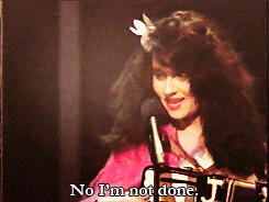 a woman singing into a microphone with the words no i 'm not done below her