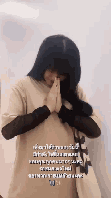 a woman is praying with her hands folded in front of her face in a photo with foreign writing