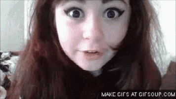 a close up of a girl making a funny face with her mouth open .